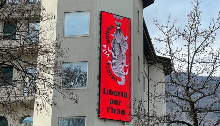 Trento, sul ledwall dell’ostello gli slogan della rivolta per la libertà in Iran