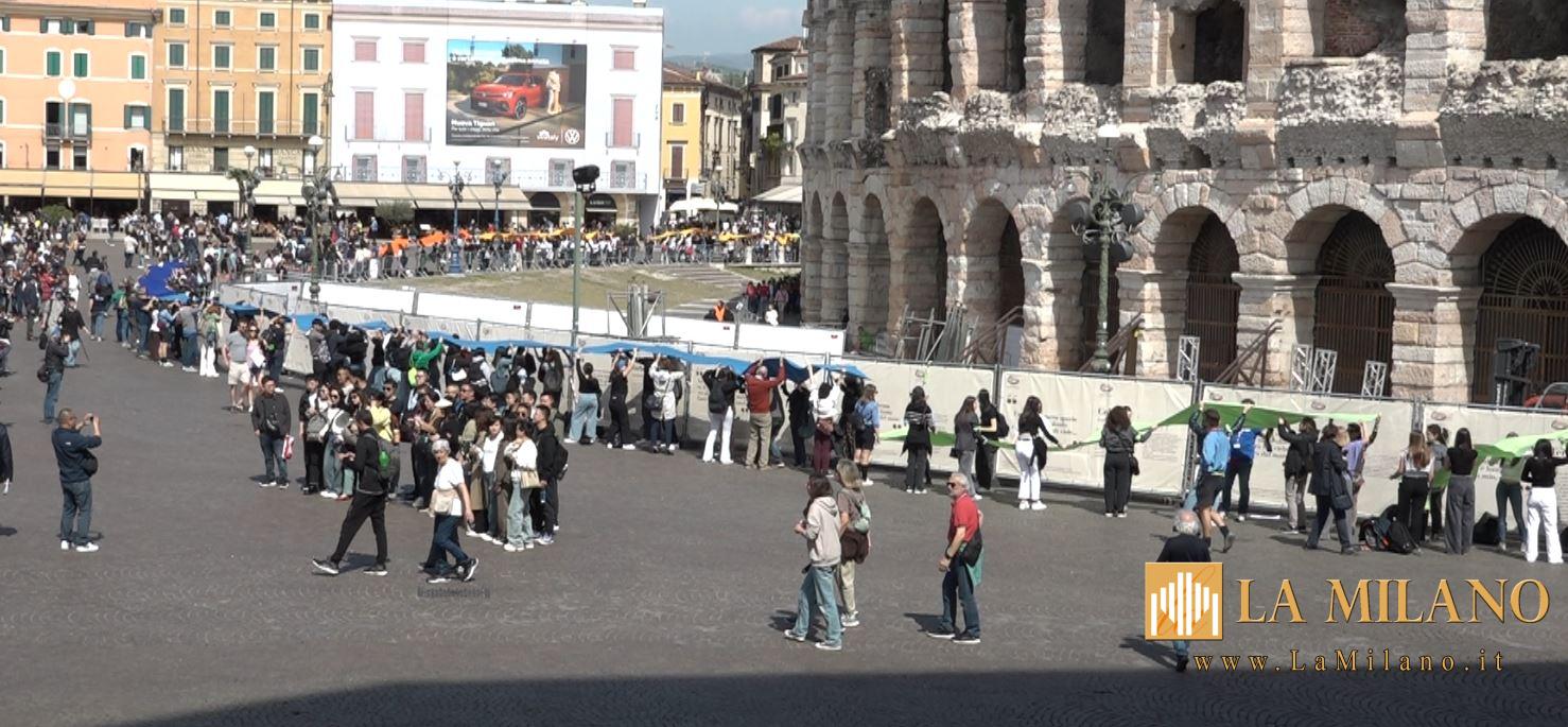Verona. In Piazza Bra il flash mob degli studenti. 600 giovani che sostengono 500 metri di tessuto colorato per un simbolico abbraccio all'Arena per l'Agenda 2030 e per la sostenibilità.