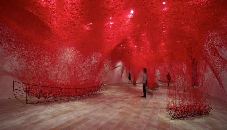 Il MAO Museo d’Arte Orientale di Torino presenta “Chiharu Shiota: The Soul Trembles”, una delle più grandi e importanti esposizioni monografiche dedicate all’artista giapponese. Curata da Mami Kataoka, direttrice del Mori Art Museum e ideatrice del progetto originale, insieme a Davide Quadrio, direttore del MAO, la mostra arriva in anteprima nazionale e, per la prima volta in assoluto, in un museo di arte asiatica italiano, dopo un tour internazionale in istituzioni prestigiose come il Grand Palais di Parigi, il Busan Museum of Art, il Long Museum West Bund di Shanghai, la Queensland Art Gallery di Brisbane e lo Shenzhen Art Museum. Un progetto imponente e poetico, che ripercorre l’intera carriera di Shiota attraverso disegni, fotografie, sculture e alcune delle sue più celebri e suggestive installazioni ambientali, celebri in tutto il mondo per la loro capacità di avvolgere, sospendere e trasformare lo spazio. Un viaggio immersivo tra fili, memorie e domande universali Il percorso espositivo si configura come una grande installazione diffusa, che si espande dalle sale temporanee alle gallerie permanenti del museo, creando un dialogo sensibile con le collezioni asiatiche del MAO. Le opere di Chiharu Shiota affrontano temi come memoria, identità, relazione con l’altro, tempo, assenza, vita e morte, esplorando l’intangibile attraverso trame visive di straordinaria forza emotiva. I celebri fili rossi o neri, intrecciati in grandi strutture spaziali, diventano metafora di legami, fragilità e tensioni interiori. Tra le opere più iconiche presenti in mostra: Where Are We Going? (2017) – il motivo della barca, ricorrente nella poetica di Shiota, evoca destini incerti e futuri in divenire. Uncertain Journey (2016) – scheletri di imbarcazioni immerse in una rete di fili rossi, simbolo degli incontri e delle traiettorie che costellano ogni percorso umano. In Silence (2008) – un pianoforte bruciato e sedute per un pubblico fantasma avvolti da fili neri: il silenzio dopo la distruzione. Reflection of Space and Time (2018) – un abito e la sua immagine riflessa che interrogano la presenza nell’assenza. Inside – Outside (2009) – un’opera sul confine tra interno ed esterno, privato e pubblico, Oriente e Occidente. Accumulation – Searching for the Destination (2021) – una monumentale installazione composta da centinaia di valigie oscillanti, simbolo di viaggio, memoria, migrazione. Le voci dei curatori: un dialogo tra esistenza e collezioni asiatiche “Siamo stati portati a riflettere sulla vita, sulla morte e sulla natura dell’esistenza,” afferma Mami Kataoka, ricordando come la mostra, inaugurata nel 2019 a Tokyo, abbia attraversato anni segnati dalla pandemia e da conflitti globali. Per Davide Quadrio, la mostra segna un passo importante nella trasformazione del MAO: “Da museo di arte antica a luogo del contemporaneo, di cura e di tempo lento.” Le installazioni di Shiota, monumentali e intime allo stesso tempo, trasformano il museo in un organismo vivo, in continua evoluzione. Public Programme, attività educative e catalogo bilingue Come tutte le grandi produzioni del MAO, anche “The Soul Trembles” sarà accompagnata da: public programme musicale e performativo proiezioni, incontri e conferenze laboratori per scuole, famiglie e adulti percorsi accessibili in International Signs, grazie alla collaborazione con l’Istituto dei Sordi di Torino La mostra è inoltre accompagnata da un catalogo bilingue italiano-inglese edito da Silvana Editoriale, con testi di Kataoka e Quadrio e contributi di studiosi internazionali. Un nuovo capitolo: un’opera inedita al MUDEC di Milano Dal 19 novembre 2025, un’opera inedita di Chiharu Shiota, The Moment the Snow Melts, sarà visibile al MUDEC di Milano nell’ambito del progetto “Il senso della neve”. Una riflessione sulla precarietà della neve come metafora della natura effimera delle relazioni umane. Biografie Chiharu Shiota (Osaka, 1972) Artista riconosciuta a livello internazionale, vive e lavora a Berlino. Vincitrice del Premio all’Incoraggiamento delle Arti del Ministero giapponese della Cultura (2008, 2024), è stata protagonista di mostre in istituzioni di primo piano e ha rappresentato il Giappone alla 56ª Biennale di Venezia. Mami Kataoka Direttrice del Mori Art Museum dal 2020, alla guida anche del National Center for Art Research e dell’ICA Kyoto. È stata direttrice artistica di biennali internazionali e presidente del CIMAM.